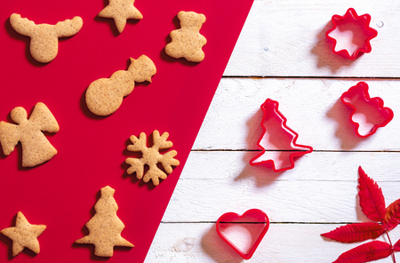 Red and white Christmas baking concept with ginger cookies in different Xmas shapes and cookie cutters. Minimalist Christmas context.の写真素材