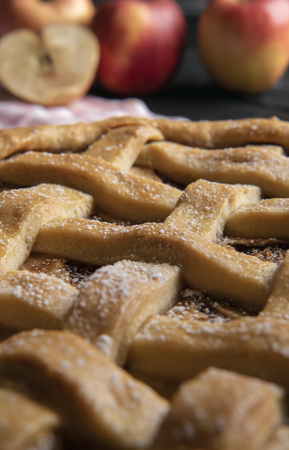 Details with the crust of an apple pie with lattice shape. Classic baked sweet pie. Traditional desserts. Close-up image with selective focus.の写真素材