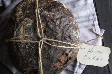 Brown bread with delicious crust tied up with a rope and a paper messageの写真素材