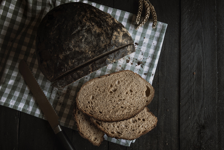 Sliced bread on a rustic wooden table. Flat lay image with home baked brown bread