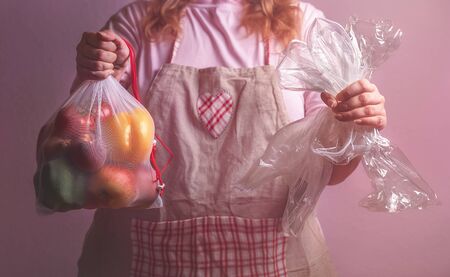 Sustainable lifestyle concept with a woman holding an eco-friendly bag with vegetables and empty groceries plastic wrappers. Plastic-free conceptの写真素材