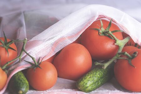 Eco bag with fresh vegetables, tomatoes, and cucumbers. Groceries in a reusable bagの写真素材
