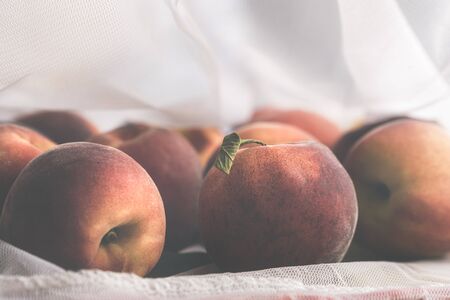 Ripe peaches in a reusable mesh shopping bag. Reduce the plastic wrapping concept. Plastic packaging management concept. Groceries in an eco bag.の写真素材