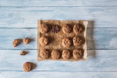 Homemade bread buns with rye flour and hazelnuts, on the baking paper, on a wooden kitchen table....