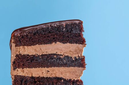Birthday cake slice with chocolate filling. Close-up of chocolate layered cake with buttercream...