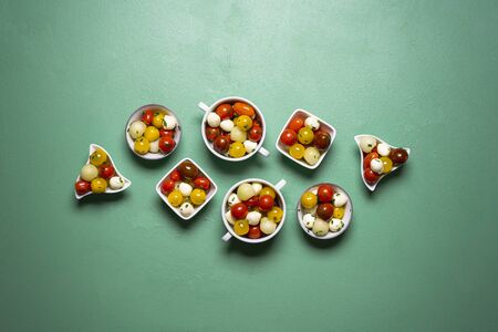 Summer salad with cherry tomatoes, melon and mozzarella balls in many bowls.の写真素材