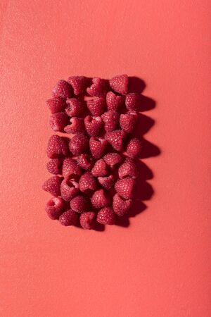 Raspberry pile in a rectangle shape on a lush lava table. Above view of freshly collected...