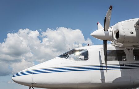 Modern plane with propellers side-view on a background of blue sky with white clouds. Aircraft...