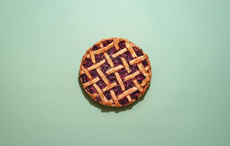 Home-baked cake with blueberries filling and lattice crust, top view. Flat lay with a delicious blueberry tart on a green background.の写真素材