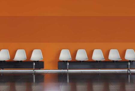 White chairs in a row against an orange wall inside a modern building. Empty chairs in a waiting roomの写真素材