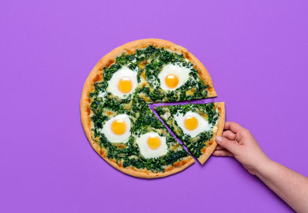 Woman grabbing a slice of pizza. Flat lay, vegetarian pizza with spinach, mozzarella and eggs, isolated on a purple background. Homemade Italian dishの写真素材