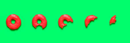 Eating a red donut, collage on a green background. Top view with a glazed doughnut from the whole product till the last bite.の写真素材