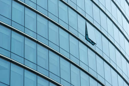 Close-up with the from a modern glass building. Office building with a single window open.