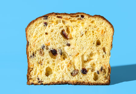 Cross section from a homemade panettone, minimalist on a blue table. Sourdough panettone texture in bright light.の写真素材