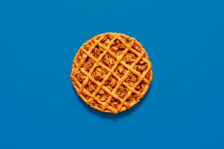 Top view with a homemade apple pie isolated on a blue background. Freshly baked lattice crust cake with apple fillingの写真素材