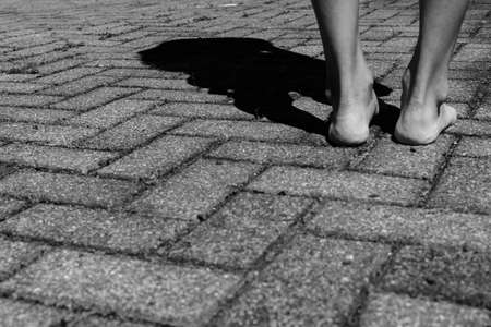 Barefoot. Feet in a corner with rough bricks, a loneliness image.の写真素材