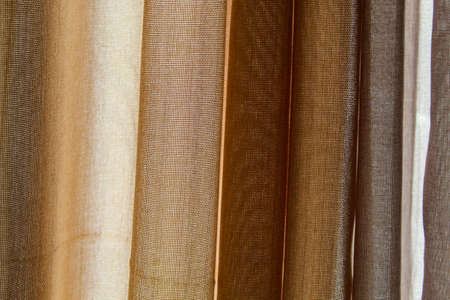 Fabric texture. Curtains. Fabric in vertical position with gray and brown colors.
