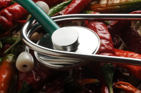 Stethoscope on background of spicy chilliesの写真素材