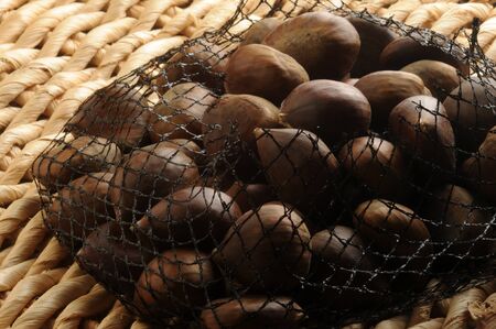 Close up of raw chestnuts in the netの写真素材