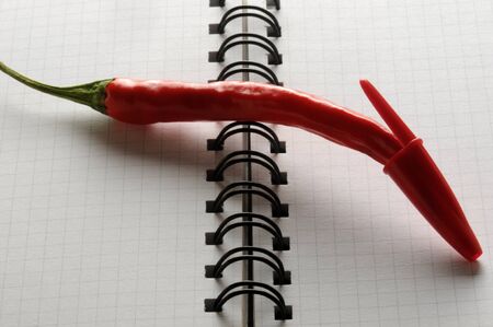 Cap of a red pen on hot pepperの写真素材
