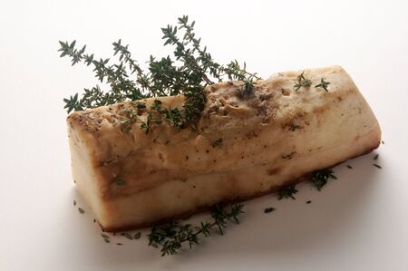 Piece of lard with herbs on white backgroundの写真素材