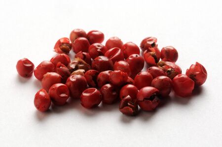 Heap of red peppercorns on a white background