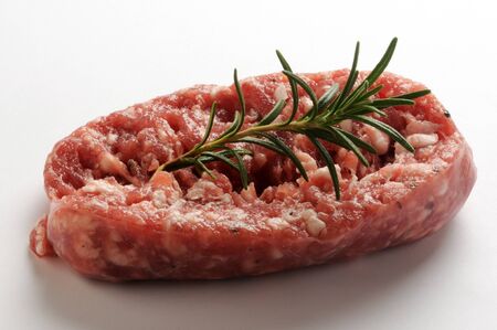 Raw sausage with rosemary on a white backgroundの写真素材