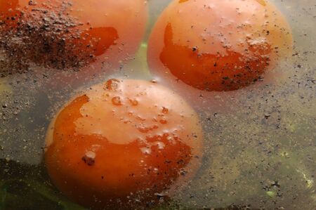 Fresh raw eggs with black pepperの写真素材