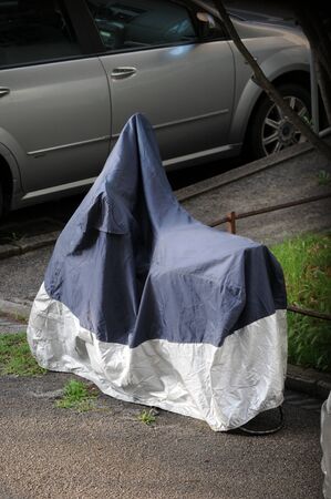 Motorbike with protective cover on the winter roadの写真素材