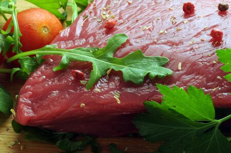 Slice of raw meat with arugula and spicesの写真素材