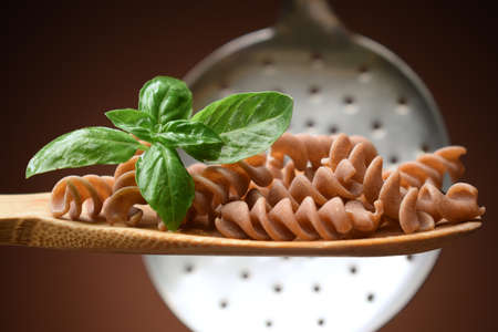 Whole wheat fusilli on the spoonの写真素材