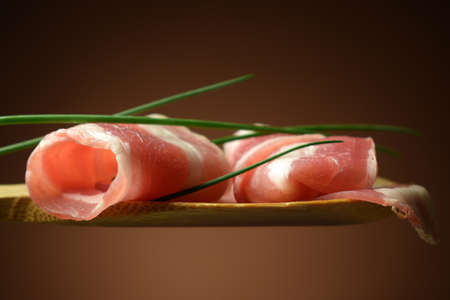 Pancetta slices with chives on spoonの写真素材