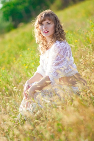 Portrait of a beautiful young brown-haired woman in nature in a lace dressの写真素材