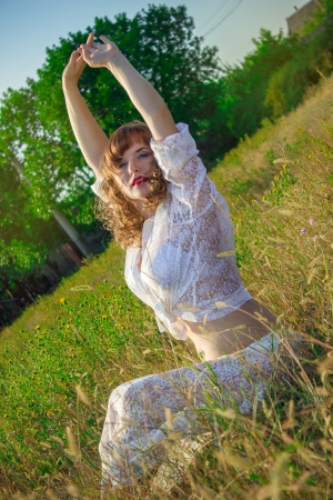 Portrait of a beautiful young brown-haired woman in nature in a lace dressの写真素材