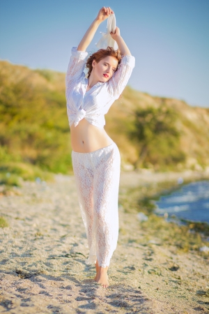 Portrait of a beautiful young brown-haired woman in nature in a lace dressの写真素材