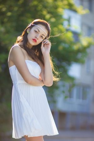 Portrait of a beautiful brunette girl in a short dress with bright makeupの写真素材