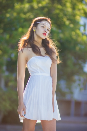 Portrait of a beautiful brunette girl in a short dress with bright makeupの写真素材