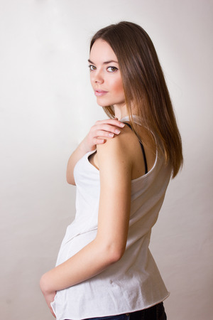Portrait of a beautiful young woman in a white T-shirt with natural make-up and straight brown hairの写真素材