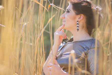 Young pretty brunette woman posing outdoor in summer meadow  Sensual girl posing in parkの写真素材