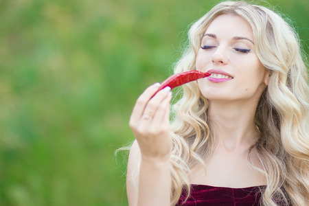 Portrait of an attractive young woman holding up pepperの写真素材