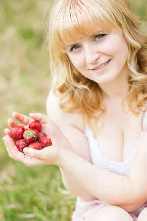 Woman with strawberries outdoorの写真素材