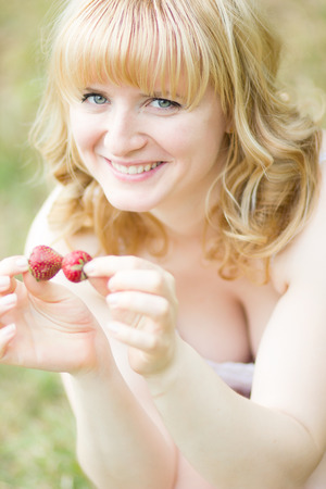 Woman with strawberries outdoorの写真素材