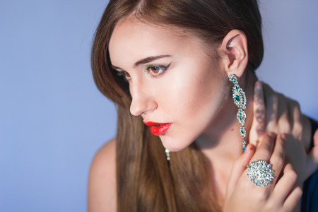 Elegant Posh Woman with Diamond Earrings And Ring. Platinum Jewelry with green And White Diamondsの写真素材