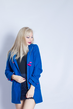 Portrait of a beautiful young woman dressed in a blue warm coat. Girl in the studio
の写真素材