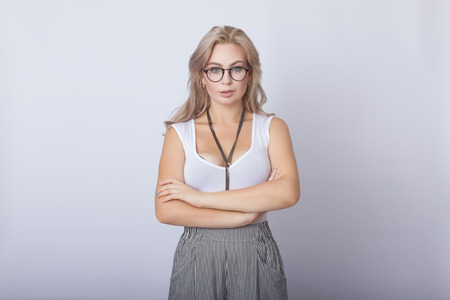 Portrait of smiling beautiful blonde woman looking camera over grey backgroundの写真素材