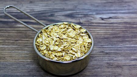 oatmeal or hercules flake close-up on a plate on wooden background. Healthy diet. Oatmeal porridge.