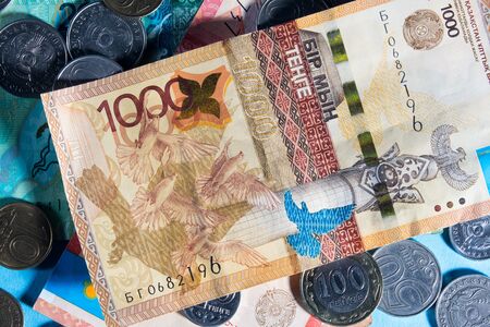 Tenge on a blue background with coins. Tenge banknotes. Coins Of Kazakhstan Tengeの写真素材