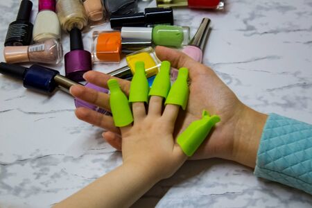 Children's manicure. Children's beauty salon. Paint your child's nails with nail Polish. Nail Polish remover clips on the girl's fingers.の写真素材
