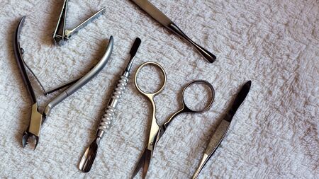 Equipment for beauty shop,cosmetic salon or beauty parlour.Manicure tools in the beauty salon.Equipment for manicure or pedicure salon.Scissors,pliers,tweezers, blade and nail the clamps on the table.の写真素材