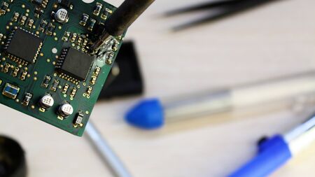 Workshop on repair of household appliances, electronics and processors. soldering Board soldering iron, re-soldering chips, replacing transistors, thyristors, capacitors and varistors. Soldering tinの写真素材